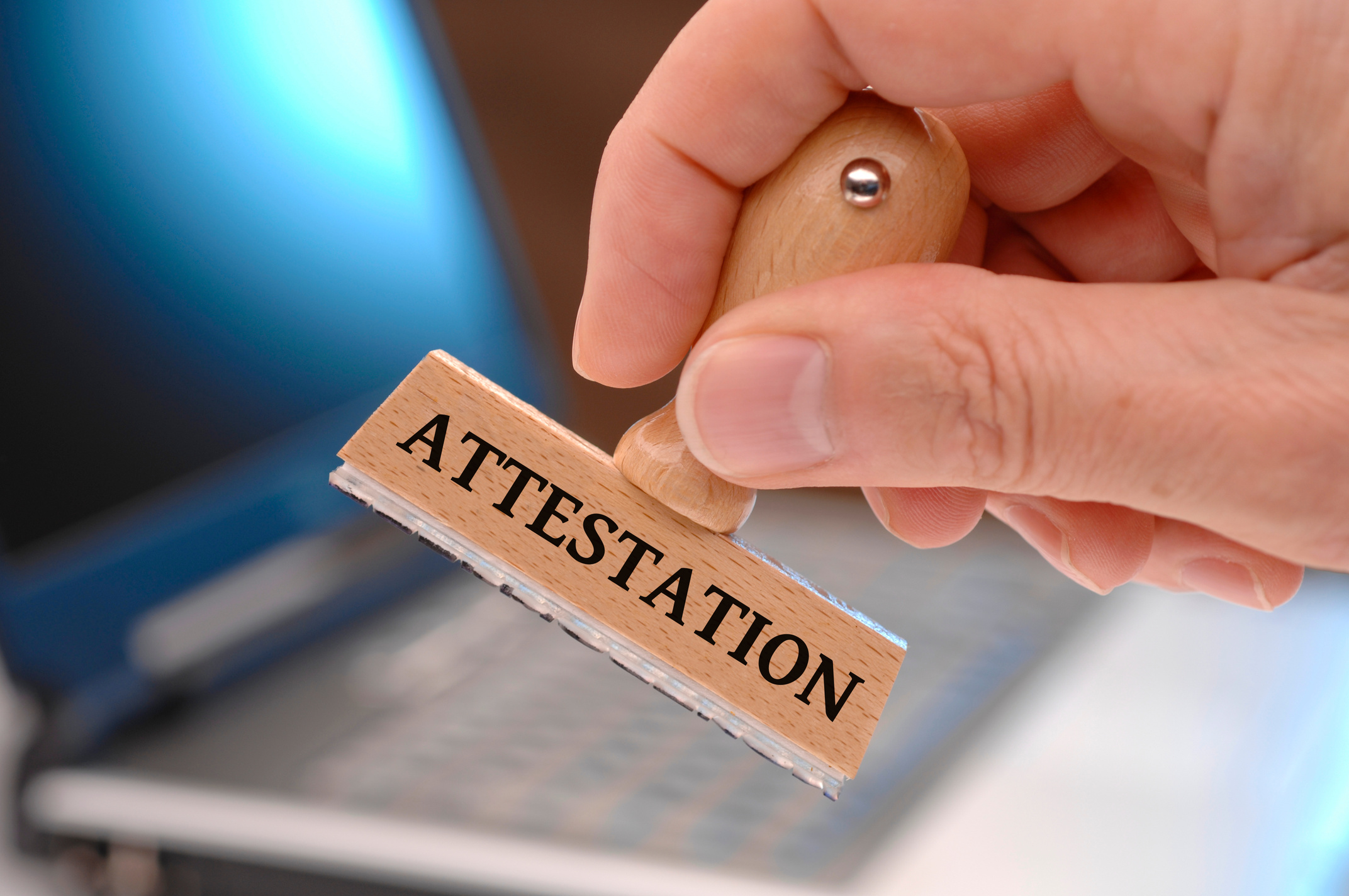 attestation  printed on rubber stamp in hand